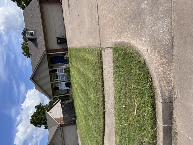 Same front yard freshly mowed and edged after service